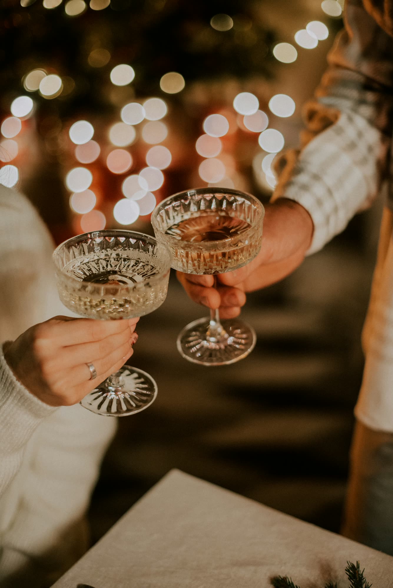Two people clinking crystal coupe glasses at an evening celebration, generic stock photo pending real venue photography.