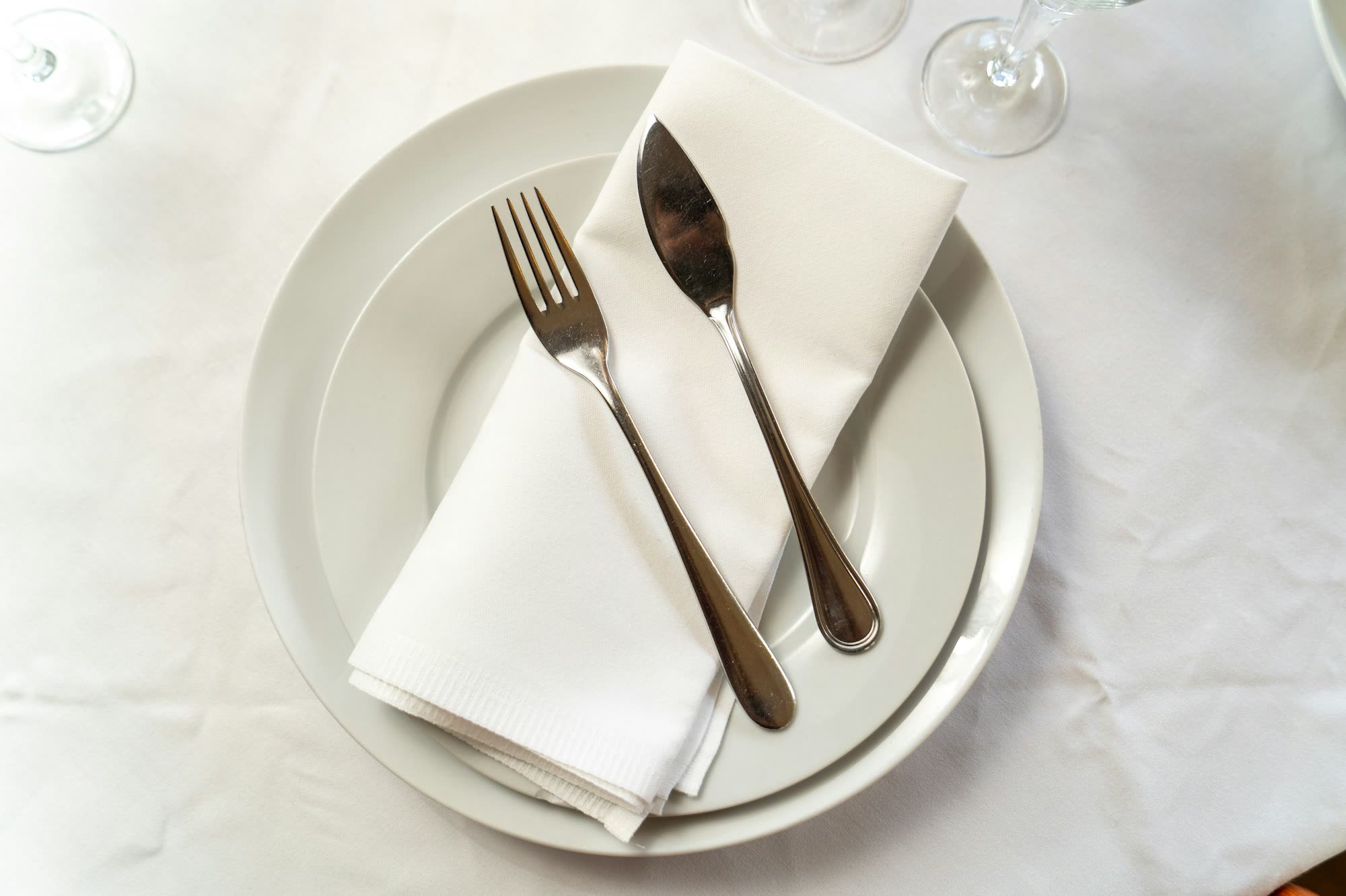 An overhead view of a place setting with a folded napkin and cutlery, generic stock photo pending real venue photography.